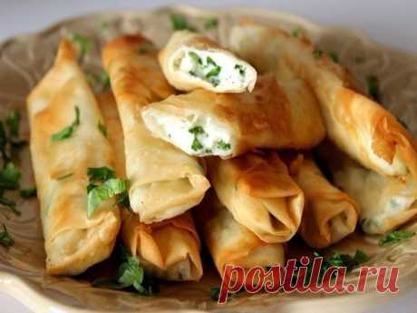 СЫРНЫЕ ПАЛОЧКИ ИЗ ЛАВАША 🌿 Вкуснейшая закуска ✔ ИНГРЕДИЕНТЫ: ● Лаваш − 1 шт. ● Сыр плавленый − 2 шт. ● Яйца − 2 шт. ● Сливочное масло − 1 ст.л. ● Зубчик чеснока − 2 шт. ● Укроп − 5 г ПРИГОТОВЛЕНИЕ: 1. Нарезаем плавленые сырки тонкими полосками, яйца хорошо взбиваем. 2. Чеснок необходимо измельчить, а укроп мелко порубить. Лаваш разрежьте на полоски (длина 8-10см, ширина 10-12 см). 3. Затем берем полоску лаваша, кладем в нее по длине две полоски сыра, немного чеснока, сверху посыпаем зеленью и…