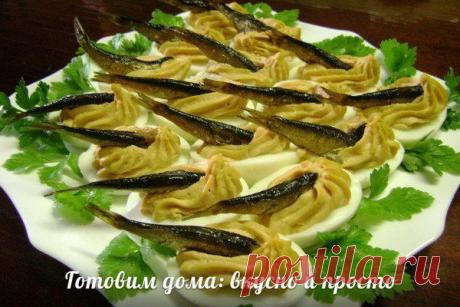 Шпротинки в яйце

Состав:
-яйца
-чеснок
-шпроты

Отварить яйца, разрезать пополам, вынуть желток. 
В миску сложить желтки, тертый сыр немного, 2 зубчика чеснока, ложку томата. 
Налить масло с шпрот и пару ложек майонеза и взбить блендером в крем. 
Крем отсадить через корнетик с насадкой в половинки белка яиц и в каждую погрузить шпротинку.