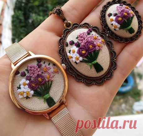 two needle - embroidered flowers are sitting on top of each other in the palm of someone's hand