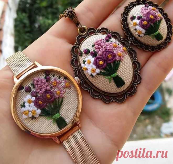 two needle - embroidered flowers are sitting on top of each other in the palm of someone's hand