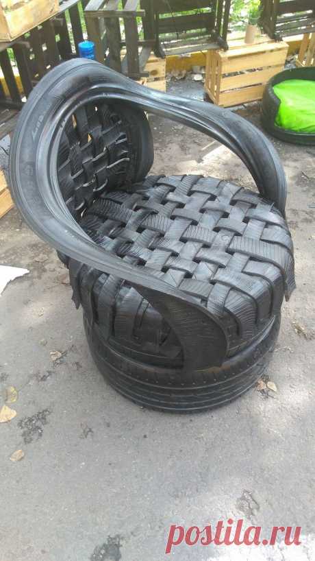 an old chair made out of tires sitting on the ground