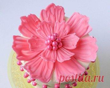 ШОКОЛАДНЫЙ ЦВЕТОК ДЛЯ УКРАШЕНИЯ ТОРТА 
пошаговая инструкция от Erin Гарднер
Ингредиенты
Маслянный крем для торта
Шоколад (немного отложите для фиксации конфет в центре цветка)
Конфетки для центра цветка
Шпатель
Кондитерский мешок
Пергамент
Небольшие чаши или круглые пластиковые контейнеры
Черный маркер
Ножницы
Лента клейкая
Красители (опционально)
Используйте черный маркер, чтобы нарисовать треугольники на пергаментной бумаге различных размеров. Эти треугольники будут служ...