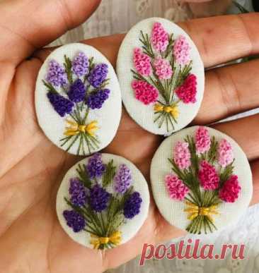 three handmade buttons with flowers on them in the palm of someone's hand