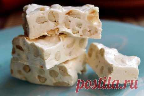 Мягкая нуга с орехами и курагой (Torrone morbido)

Ингредиенты:
-2/3 стакана меда
-2 яичных белка
-1 стакан обжаренного миндаля
-1/2 стакана нарезанной кураги
-цедра половины лимона

Приготовление:
Подготовьте глубокий противень, застелив его восковой бумагой или пергаментом для выпечки. 
Мед выложите в термостойкую миску и поставьте на водяную баню. Дайте меду время растопиться, в это время взбейте белки до устойчивых пиков. 
Введите их в теплый жидкий мел и перемешайте д...