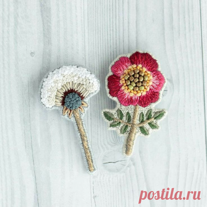 two crocheted flowers sitting next to each other on top of a white table
