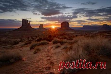 A Path to the Sun Hoof Prints from a horse who came through the campsite I was staying in the night before leads off to the sun rising between the Monument Valley Mitts in the Monument Valley Navajo Tribal Park in Northern Arizona.