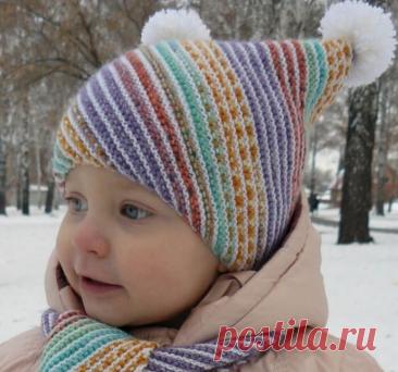 Детская шапочка спицами Размер: на возраст 2 года. *Обхват головы: 46 см.Для вязания потребуется:пряжа Opal Solids,100 г на 425 м, молочного цвета – 100 г;пряжа Opal Regenvald 6-Ply, 150 г на 420 м – 60 г;спицы №2,5.Плотность: на платочной глади сп. №2,5 26 п. на 15 р. равны 10 см на 10 см.Основной узорПлаточная...