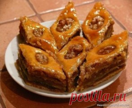 Пахлава 
Ингредиенты:
- Масло сливочное - 350 г 
- Сметана - 300 г 
- Яйца куриные - 4 шт. 
- Мука - 4 ст. 
- Сода - 1 ч.л. 
- Сахар - 2,5 ст. 
- Грецкий орех - 2 ст. 
- Мед - 2 ст.л. 
Приготовление:
Вначале приготовить тесто. Муку перетереть с 300 г масла в крошку. Добавить 3 желтка, сметану и соду, замесить тесто, убрать его в холодильник на 1 час. 
После достать, разделить на одинаковых 8 шариков. 
Подготовить начинку: орехи перемолоть, но не в муку, а чтоб оставались кусочки. 
Соединить 4