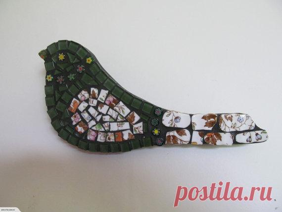 Mosaic Bird - Green with Crockery wing and tail Mosaic Green with Crockery Bird wall hanging. Made by myself using glass tiles, millefiori glass beads and a crockery wing. Bird has been grouted and sealed. The back and sides are painted black. The base is MDF and is best to be hung inside. Size is 25cm across widest point x 11cm in length.