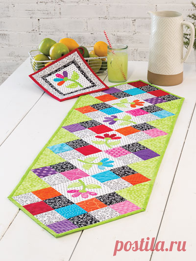 EXCLUSIVELY ANNIE'S QUILT DESIGNS: Flower Patch Table Runner Pattern This table runner features a row of appliqued flowers bordered with colorful patchwork. The coordinating pot holder has a single appliqued flower. Finished size is 50 1/2