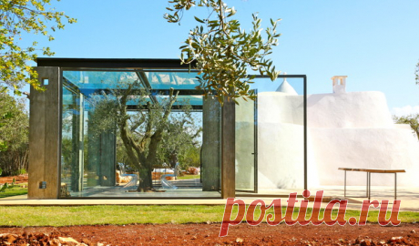 Архитектор Энрико Мария Чинкетти не только восстановил старинный дом-труллоо, но и дополнил его стеклянным кубом, который выстроил вокруг оливы. Сейчас этот куб служит открытой террасой и зимним садом, объединяя старинную архитектуру и современность. Показываем дом-трулло со стеклянной пристройкой »