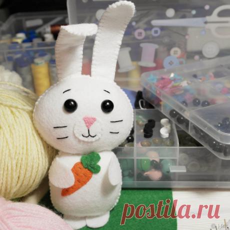 Шьем Зайку из фетра Делюсь с вами авторской выкройкой и мастер-классом зайки, которого можно поселить на мобиль, гирлянду или оставить в виде игрушки. Нам понадобится: - фетр (белый, оранжевый, зеленый, розовый); - нитки в цвет фетра; - наполнитель (холофайбер, синтепон, синтепух); - безопасные глазки для игрушек (можно заменить на пришивную деталь); - иголка; - ножницы; - скотч; - нити для вышивания мордочки.