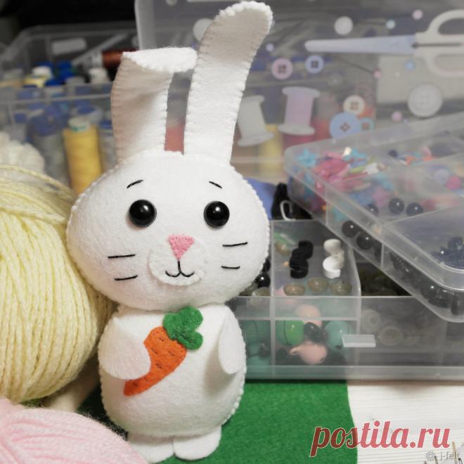 Шьем Зайку из фетра Делюсь с вами авторской выкройкой и мастер-классом зайки, которого можно поселить на мобиль, гирлянду или оставить в виде игрушки. Нам понадобится: - фетр (белый, оранжевый, зеленый, розовый); - нитки в цвет фетра; - наполнитель (холофайбер, синтепон, синтепух); - безопасные глазки для игрушек (можно заменить на пришивную деталь); - иголка; - ножницы; - скотч; - нити для вышивания мордочки.