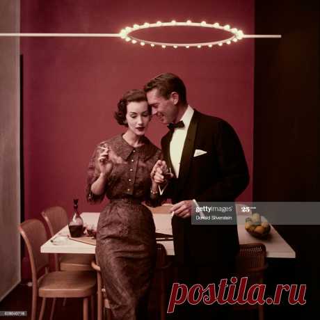 Ruth Neuman Derujinsky is wearing a shirtwaist dress in Chantilly lace with wide collar and sprinkling of rhinestones based on Vogue Pattern, Oct. 1954