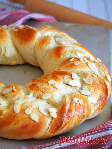 Финская Pulla Bread-Женщина Строчит Каракули Финский хлеб пулла-это красиво плетеный венок, который получает свой приятный аромат от кардамона, и он украшен хрустящим миндалем в качестве отделки сверху.