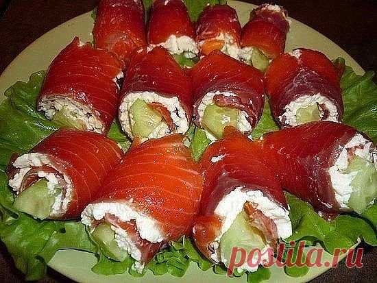 ТОП-7 новогодних
закусок. 1. Рулетики из лосося со сливочным сыром Ингредиенты: ● ломтики
слабосоленого лосося 250 г ● сливочный сыр 250 г ● маринованные или свежие
огурцы 1-2 шт. ● веточки укропа 3-4 шт. ● листья салата для подачи ● лимонный
сок для подачи ● красная икра для украшения Приготовление: Укроп промыть,
обсушить и измельчить. Огурцы мелко нарезать.Смешать в небольшой миске
сливочный сыр, укроп и нарезанные огурцы.Расстелить на столе пленку и разложить
на ней ло...