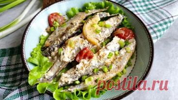 Рыбное блюдо с мойвой, луком, помидорами черри и лимоном, которое томится под крышкой около 20–25 минут.
