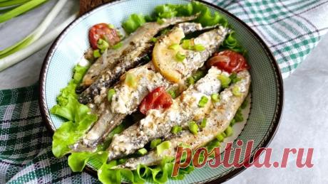Рыбное блюдо с мойвой, луком, помидорами черри и лимоном, которое томится под крышкой около 20–25 минут.
