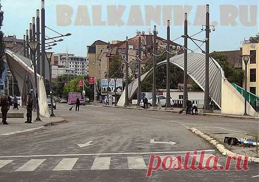 Митровица 2013 | Балканика.ру
Косовска Митровица – один из городов Косово, в принципе, ничем не примечательный, кроме того, что через него волей судьбы легла граница между сербской частью Косова и теперь уже албанской.
И проходит эта граница через небольшой мост, имеющий аж целых три названия, но какое из них реальное… я всё-таки склоняюсь к сербскому — Ибарский, так как мост построен через реку Ибар. Албанцы называют его Митровицким.