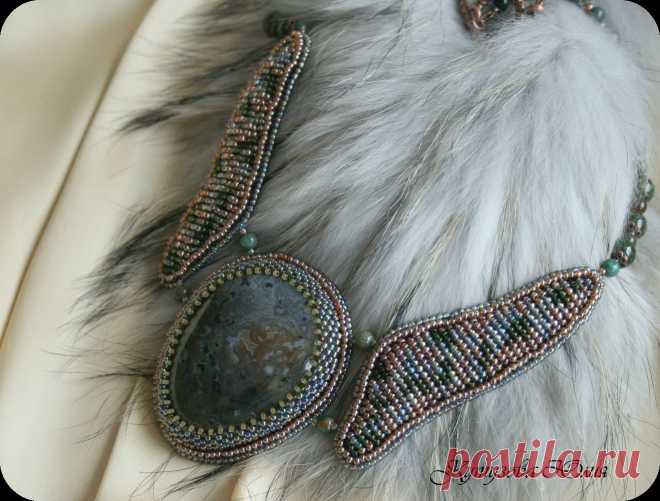 Колье "Секрет леса" с моховым агатом. 
 
Использован японский серый хамелионовый и зеленый бисер №11, Коричневый чешский бисер №10, и матовый песочный японский бисер №15.Также использованы бусины индийского агата и змеевика. Фурнитура под медь. Обратная сторона подшита натуральной черной кожей. 
Размер центрального эллемента около 6.5х5см, длина по меньшей стороне около 50 см