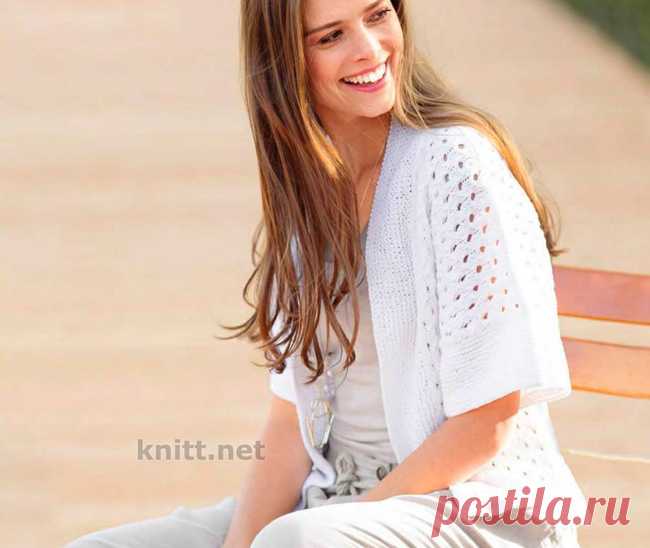 Вязаный спицами белый жакет без застежки Вязаный спицами белый жакет без застежки станет хитом сезона: белоснежная пряжа особенно эффектно подчеркивает сетчатый узор, обрамленный широкими планками