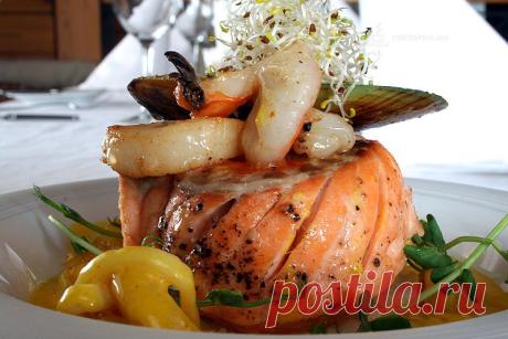 Форель с ароматными травами, на подушке из риса с соте из морепродуктов.