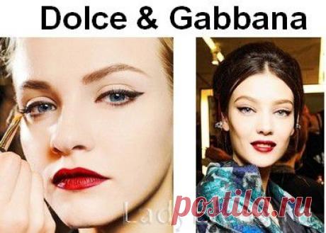 Dolce &amp; Gabbana в своем макияже 2014 года делает акцент на губы, используя при этом классическую вишнево-алую помаду. Брови естественные и подчеркнуто широкие. Глаза обрамляют черные выразительные стрелки. Гладкие волосы собраны в низкий пучок, который особенно актуален в этом сезоне, длинная челка разделена прямым пробором.