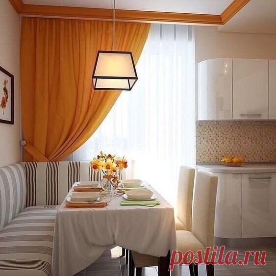 Светлая кухня с акцентом на яркие оранжевые шторы. И вполне уютная обеденная зона с диванчиком
