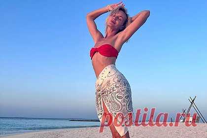 Полина Гагарина показала фигуру в купальнике. Российская певица Полина Гагарина показала фигуру в откровенном наряде на отдыхе. На размещенных кадрах 36-летняя артистка примерила на фоне моря и белого песка красный раздельный купальник, состоящий из бюстгальтера-бандо и плавок с низкой посадкой. Поверх плавательного костюма на область бедер звезда повязала парео.