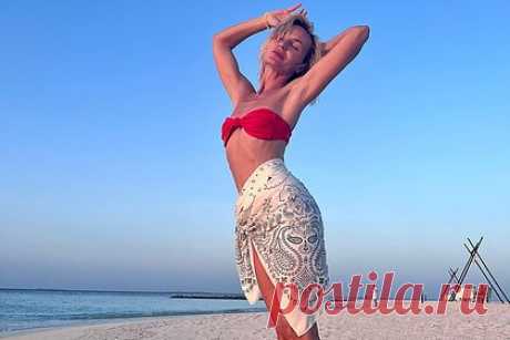 Полина Гагарина показала фигуру в купальнике. Российская певица Полина Гагарина показала фигуру в откровенном наряде на отдыхе. На размещенных кадрах 36-летняя артистка примерила на фоне моря и белого песка красный раздельный купальник, состоящий из бюстгальтера-бандо и плавок с низкой посадкой. Поверх плавательного костюма на область бедер звезда повязала парео.