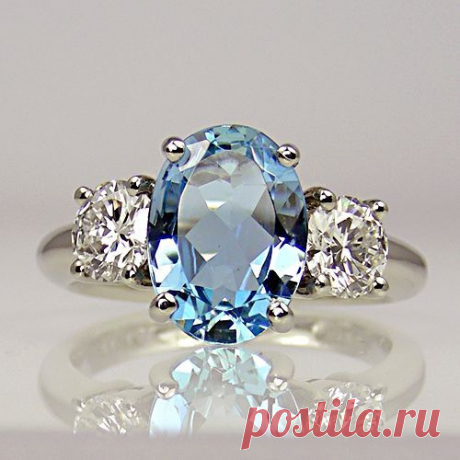 Oval aquamarine with two round brilliant-cut diamonds, one either side, all in claw-collets on platinum shank...simply stunning #aquamarinering