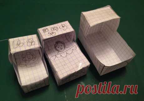three boxes with drawings on them sitting on a green surface
