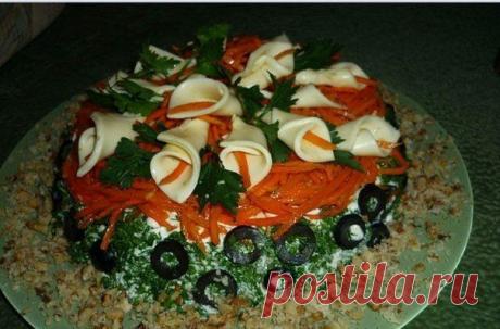 Оформление салата.
Украсить пластинами плавленного сыра, зеленью, морковью по-корейски, маслинами, грецкими орехами.