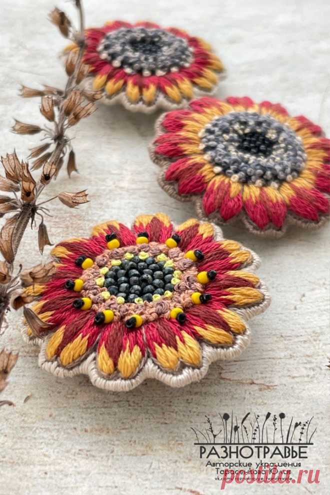 three flower brooches sitting on top of a table