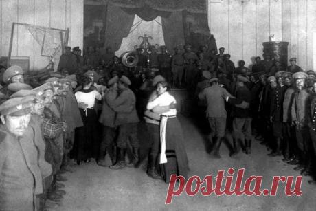 Солдатский бал. Две кухарки танцуют с солвремями, стоит рота, играет на сцене оркестр, вот такие они скромные балы у русских солдат. Первая мировая война, 1915 года. / Историческая справка