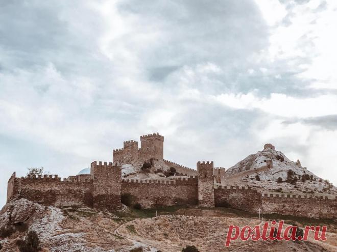 Древняя крепость у светлого города Эта крепость строилась так, что должна была стать неприступной. На скале, с одной стороны которой яростно билось море. С одним входом – чтобы у врага не было шанса зайти тайно, и чтобы при обороне не распылять силы. Издалека генуэзская крепость в Судаке сама кажется скорее скалой, чем делом рук человеческих. Летом склон с травой, выгорающей на солнце до песочного цвета, кажется основанием, на котором высятся стены.