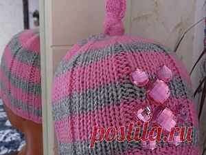 Вяжем шапочку для девочки Шапочка с мишкой из пришивных страз и узелка на макушке порадует любую маленькую модницу и непременно привлечет к себе взгляды окружающих.Связать ее можно как на круговых спицах так и на чулочных,мне ближе круговые). для изготовления этой шапочки понадобится пряжа двух цветов-розового и серого оттенка,спицы круговые,мононить и стразы пришивные. наберем на спицы 84петли далее замыкаем их в круг и…