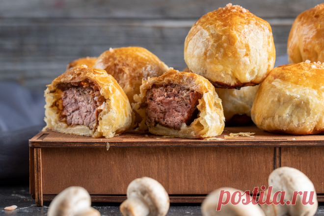 Видеорецепт: мини-веллингтон с говядиной Говядина Веллингтон – это сочная нежная говяжья вырезка, дополненная ароматными и яркими компонентами – грибами, приправами и пряностями. Получается очень вкусное, эффектное и по-настоящему праздничное блюдо. Его можно подавать в виде одного большого «пирога» или небольших, порционных вариантов.