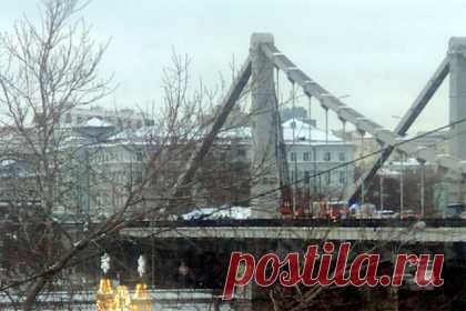 В Москве мужчина забрался на опору моста и стал угрожать самоубийством. В Москве мужчина забрался на опору Крымского моста, расположенного в центре города. Он угрожает самоубийством, однако не выдвигает никаких требований. В настоящее время психолог и спасатель уговаривают его спуститься. Высота пилона, на который залез мужчина, составляет 27 метров.
