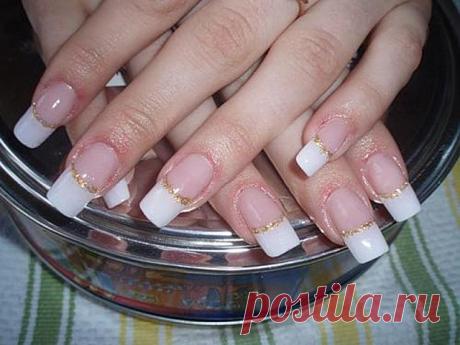 Wedding manicure with white nail polish at the free edge and gold nail polish like an ornament