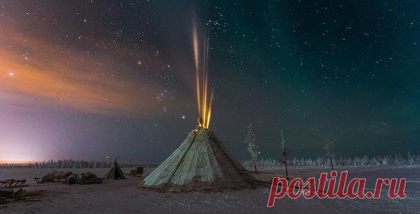 Кирилл Уютнов, автор фото: «Порывы ветра доносили звуки потрескивающих в чуме дров и запах разгорающихся лиственничных поленьев. Морозной ночью нет ничего уютней хохолка тусклого света, вырывающегося из теплого чума».