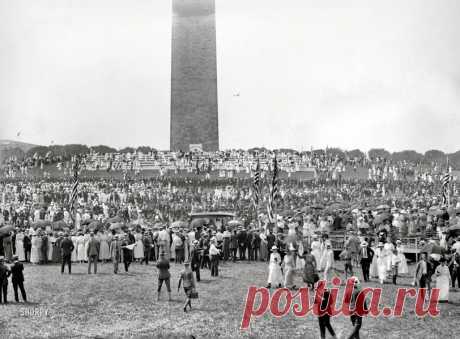 A Festive Fourth: 1919 July 4, 1919. "Washington's men and women who served during the war gathered at the base of the Washington Monument, receiving medals of honor provided by the citizens of the District of Columbia. The big crowd has just turned to watch a daring aviator circling low above the trees that surround the monument grounds." National Photo glass negative.