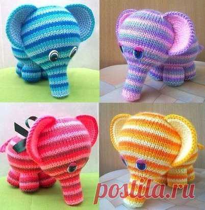 Милые вязаные слоники 
 
Потребуется: 
— разноцветная пряжа (толщина пряжи должна быть одинаковая); 
— набор из 5 носочных спиц № 2,5; 
— вязальный крючок № 2,5; 
— синтепон или холофайбер в качестве наполнителя; 
— глазки от старой игрушки. 
 
Изготовление 
 
Ножки: наберите 21 п. синей нитью и распределите по 7 п. на каждую спицу. Далее вяжите по кругу каждые 2 ряда новым цветом: синим, голубым, красным (можно использовать другие цвета). Далее вяжите розовым цветом следующим образом: 
1 ряд –