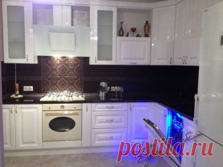 Вариант угловой кухни с фасадами МДФ эмаль глянец белая в классическом стиле с полно встраиваемой посудомоечной машиной, отдельно стоящим холодильником и наклонной вытяжкой.