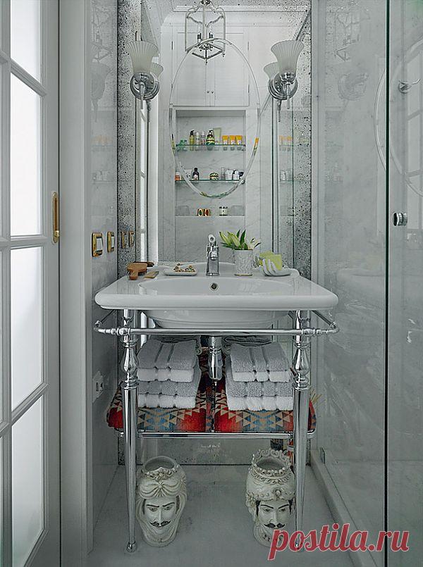 Несмотря на скромные размеры, ощущение от ванной роскошное – благодаря красивой раковине, состаренному зеркалу, отделке из мрамора, доступу естественного света, проникающему сюда через матовые вставки в дверях, и небольшому окошку, которое располагается под потолком и смотрит в сторону кухни.