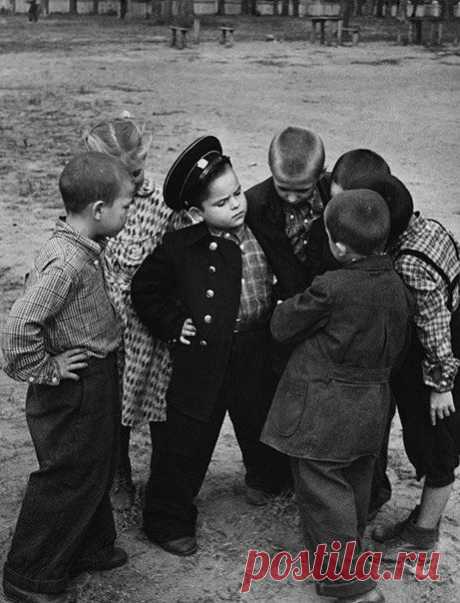 Первоклассник хвастается новой формой перед своими друзьями-дошкольниками, 1955 г. / Историческая справка