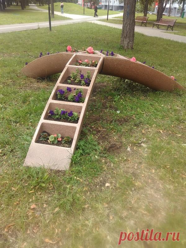 Клумба-мостик Такие трехногие клумбы с недавних пор украшают наш район. Все бы ничего, вроде красиво, благоустроено... Правда, емкости мелкие, но цветы в них не сказать, чтобы сохнут - в жару проезжающие мимо поливалки обязательно около клумб останавливаются, вылезает водитель и...