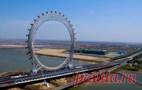 Они снова бьют рекорды: китайцы построили первое в мире колесо обозрения без оси.
Уникальное колесо обозрения, активно набирающее популярность, уже успели окрестить настоящим инженерным чудом. 145-метровая конструкция в виде кольца, возвышается над рекой Байланг в городе Вэйфан. 
Колесо обозрения, появившееся на востоке Китая, не имеет традиционных спиц и внутренних опор. Кабинки приводятся в движение за счет встроенной ходовой части. Прочность всего сооружения обеспечивают металлические констру