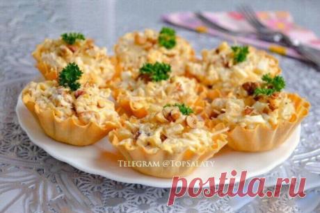 ЗАКУСКА С КУРИЦЕЙ И АНАНАСАМИ В ТАРТАЛЕТКАХ

Ингредиенты:
- Филе куриное 200 гр.
- Ананас консерв. 200 гр.
- Сыр твердый 70 гр.
- Чеснок — 1-2 зуб.
- Орехи грецкие 30 гр.
- Яйца вареные — 2 шт
- Майонез по вкусу
- Тарталетки 

Приготовление:
1. Отварную курицу порезать небольшими кусочками. Добавить порезанные кубиками ананасы. Сыр натереть на крупной терке, ядра орехов порубить ножом. Добавить сыр и орехи к остальным ингредиентам. 
2. Добавить рубленные вареные яйца с изм...