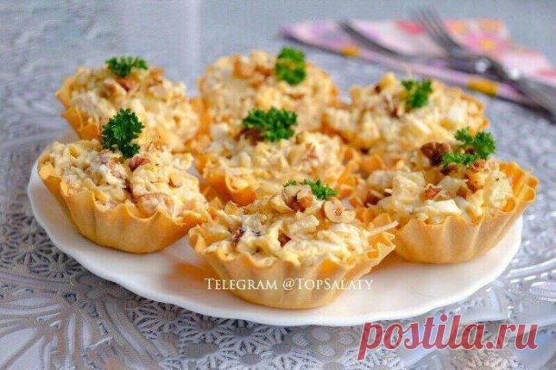 ЗАКУСКА С КУРИЦЕЙ И АНАНАСАМИ В ТАРТАЛЕТКАХ

Ингредиенты:
- Филе куриное 200 гр.
- Ананас консерв. 200 гр.
- Сыр твердый 70 гр.
- Чеснок — 1-2 зуб.
- Орехи грецкие 30 гр.
- Яйца вареные — 2 шт
- Майонез по вкусу
- Тарталетки 

Приготовление:
1. Отварную курицу порезать небольшими кусочками. Добавить порезанные кубиками ананасы. Сыр натереть на крупной терке, ядра орехов порубить ножом. Добавить сыр и орехи к остальным ингредиентам. 
2. Добавить рубленные вареные яйца с изм...